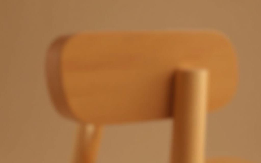 Detailed shot of a wooden chair, highlighting its ergonomic design and fine finishing.